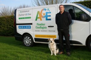 Damien Maniez, plombier chauffagiste, est debout devant sa camionnette, un chien assis à côté de lui. La camionnette est flockée avec le logo et les informations de l'entreprise ACE.